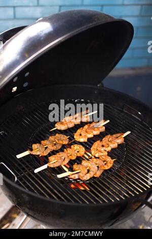 Gegrillte Garnelen auf dem flammenden Grill bei einer Sommerparty im Freien Stockfoto