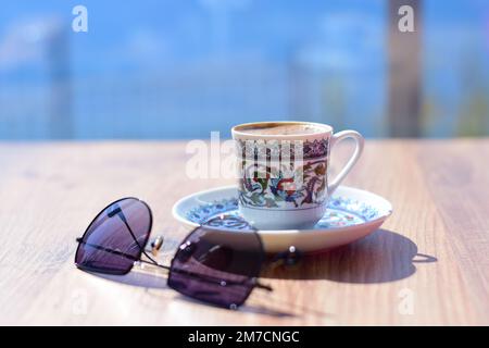 Türkischer Kaffee und Gläser im Hintergrund das Meer, Urlaubsatmosphäre Stockfoto
