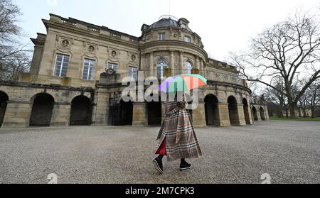 Ludwigsburg, Deutschland. 09. Januar 2023. Eine Frau mit Sonnenschirm läuft vor dem See vor dem Schloss am Monrepoes See. Kredit: Bernd Weißbrod/dpa/Alamy Live News Stockfoto