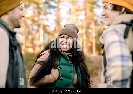 Glückliche Frau, die sich mit Freunden während des Aufenthaltes amüsiert hat Stockfoto