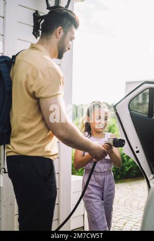 Seitenansicht eines Vaters, der seine Tochter auflädt Stockfoto