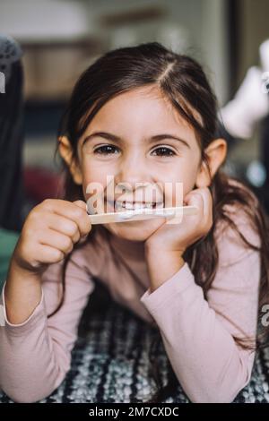 Porträt eines lächelnden Mädchens, das Eis in der Kindertagesstätte isst Stockfoto