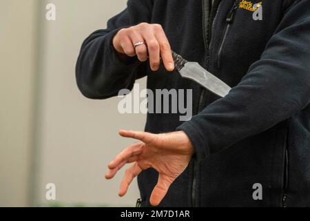 Düsseldorf, Deutschland. 09. Januar 2023. Ein Schauspieler präsentiert ein Praxismesser für die Ausbildung von Polizeibeamten, NRW Innenminister Herbert Reul besucht das Düsseldorfer Polizeiausbildungszentrum und erfährt von der Gefahr von Messerangriffen auf Polizeibeamte im Düsseldorfer Polizeihauptquartier, 27. April 2021 Kredit: dpa/Alamy Live News Stockfoto
