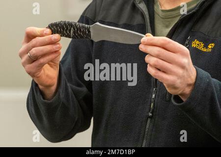 Düsseldorf, Deutschland. 09. Januar 2023. Ein Schauspieler präsentiert ein Praxismesser für die Ausbildung von Polizeibeamten, NRW Innenminister Herbert Reul besucht das Düsseldorfer Polizeiausbildungszentrum und erfährt von der Gefahr von Messerangriffen auf Polizeibeamte im Düsseldorfer Polizeihauptquartier, 27. April 2021 Kredit: dpa/Alamy Live News Stockfoto