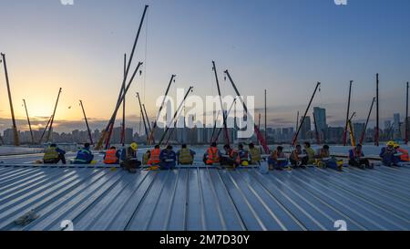 Peking, China. 31. März 2022. Die Arbeiter essen während der Pause auf der Baustelle eines Notfallkrankenhausprojekts, unterstützt von den zentralen Behörden Chinas im Lok Ma Chau Loop Gebiet von Hong Kong, Südchina, 31. März 2022. Kredit: Liang Xu/Xinhua/Alamy Live News Stockfoto