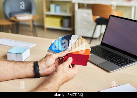Nahaufnahme eines männlichen Designers mit Farbmustern während der Arbeit im Büro, Kopierbereich Stockfoto