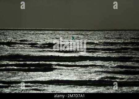 Windsurfer, die die weite Küste vor der Cornish Coast in Mounts Bay Anfang Januar genießen Stockfoto