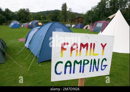 Ein Campingplatz, der in verschiedene Bereiche unterteilt wurde, einschließlich Jugend-, gemischte und Familien-Camping, indem Schilder im Gras aufgeworfen wurden. Stockfoto