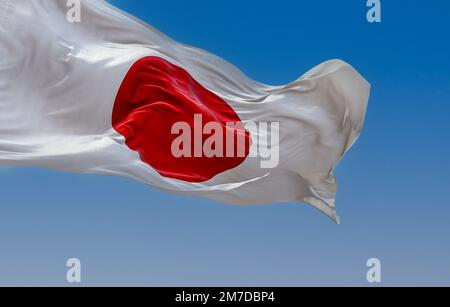 Japanische Nationalflagge, die an klaren Tagen im Wind wehte. Rote Scheibe auf weißem Feld. Japan ist ein Inselland in Ostasien. Realistische 3D-Darstellung. Stockfoto