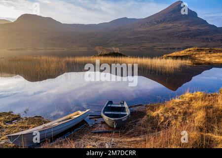 Fischerboote am Loch Lurgainn mit Sgorr Tuath in der Ferne auf der Halbinsel Coigach, Wester Ross, Highland, Schottland, Vereinigtes Königreich Stockfoto