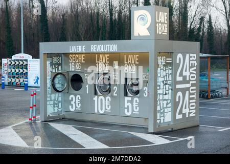 Revolution 24/7 Selbstbedienungs-Waschmaschine im Freien/Waschmaschine auf dem Gelände/Vorplatz eines französischen Supermarkts in Frankreich. (133) Stockfoto