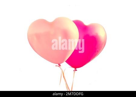 Zwei rosafarbene Ballons in Herzform, isoliert auf weißem Hintergrund, valentinstag oder Hochzeit Stockfoto