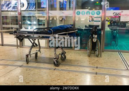 Am Genfer Cointrin International Airport in der Schweiz steht eine Trage und ein Rollstuhl bereit, um Passagieren / Flughafenhilfe oder behinderten medizinischen Notfallreisenden zu helfen. (133) Stockfoto