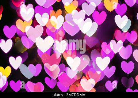 Herzförmige pinkfarbene Bokeh-Lichter, farbenfroher Hintergrund für „Liebe und Valentinstag“ Stockfoto