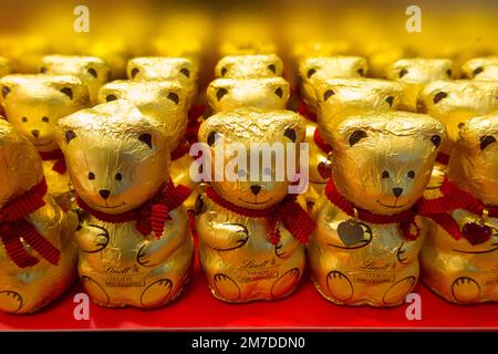 Teddybär in Folie verpackter Schokolade, hergestellt vom erstklassigen Schokoladenhersteller Lindt & Sprüngli, dem berühmten Schweizer Schokoladenhersteller, der das besonders beliebte Lindt-Kaninchen zu Ostern ergänzt. (133) Stockfoto