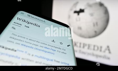 Mobiltelefon mit Webseite der Online-Enzyklopädie Wikipedia auf dem Bildschirm vor dem Logo. Fokus auf oberer linker Seite des Telefondisplays. Stockfoto