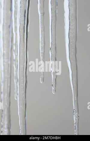 Großen Eiszapfen hängen von einem Haus glitzern im Sonnenlicht wie Juwelen aus Kristall oder Glas Winter. Stockfoto