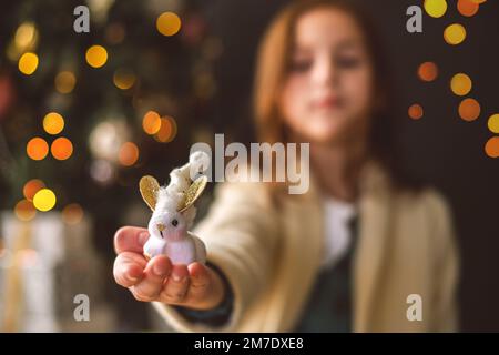 Ein süßes Mädchen hält ein Spielzeughase auf ihren Arm. Symbol für 2023 Stockfoto