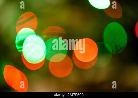 Hintergrund voller unfokussierter, farbenfroher Lichter. Unscharfe Lichterspuren und Flecken von Weihnachtsbäumen. Stockfoto