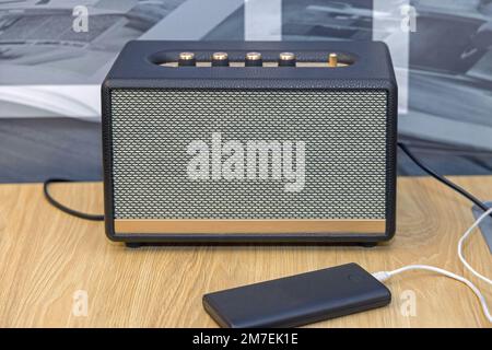 Kabelloser Bluetooth-Lautsprecher im Retro-Stil am Holzschreibtisch Stockfoto
