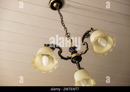 Eine alte Dreifachlampe in einem alten Hotelzimmer. Stockfoto