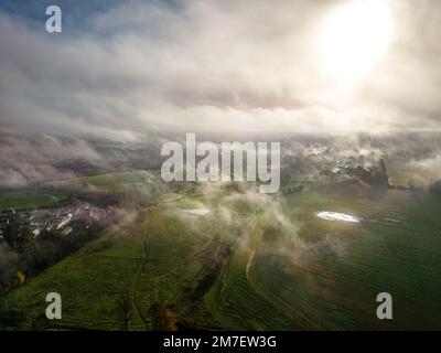 Ein nebeliger Sonnenaufgang über Cirencester in den Cotswolds, Gloucestershire. Stockfoto