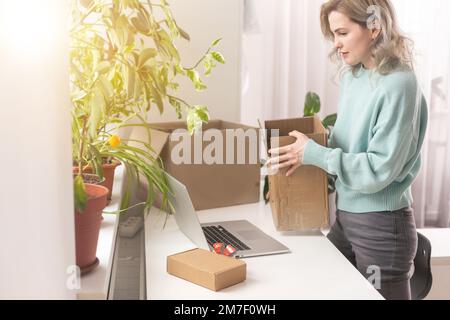 Nahaufnahme eines weiblichen Online-Shops, Inhaber eines kleinen Unternehmens, Unternehmer, der Verpackungspakete nach dem Versand vorbereiteter Versandkarton auf dem Tisch vorbereitet Stockfoto