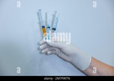 Nahaufnahme einer Hand in sterilen Handschuhspritzen Stockfoto