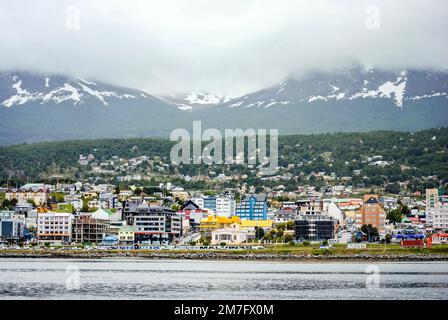 Blick auf die Stadt Ushuaia an einem bewölkten Tag vom Meer aus. Tierra del Fuego, Argentinien. Speicherplatz kopieren Stockfoto