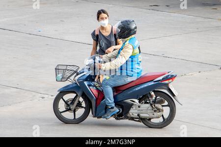 SAMUT PRAKAN, THAILAND, FEBRUAR 23 2022, Eine junge Frau reserviert eine Fahrt in einem Motorradtaxi Stockfoto