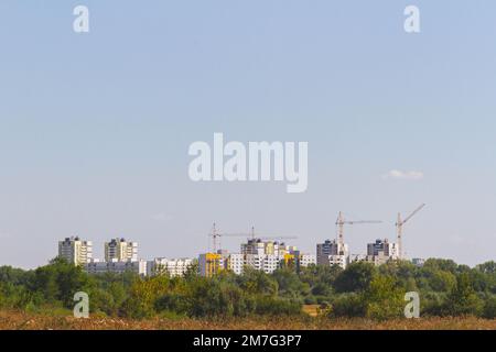 Bau von mehrstöckigen Gebäuden in ökologisch sauberen Gebieten der Stadt. Mehrstöckige Gebäude. Mehrstöckige Häuser auf dem Hintergrund eines Nat Stockfoto