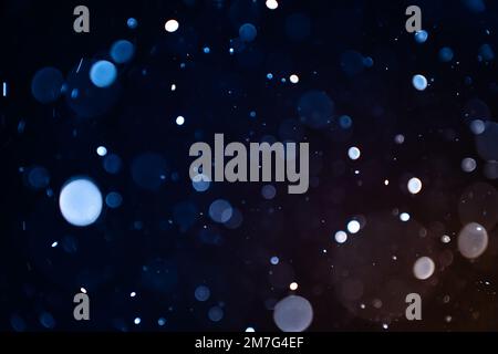 Nahaufnahme von Staubpartikeln auf schwarzem Hintergrund Bokeh-Unschärfe-Effekt mit Kopierbereich für Text. Stockfoto