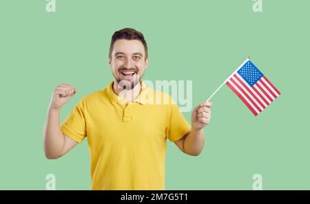 Ein glücklicher junger Amerikaner mit der Flagge der Vereinigten Staaten, der den Unabhängigkeitstag feiert Stockfoto