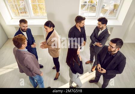 Blick von oben auf Kollegen, die im Büro kommunizieren Stockfoto