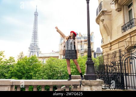 Wunderschöne junge Frau, die paris und den eiffelturm besucht. Pariser Mädchen mit rotem Hut und modischer Kleidung, die Spaß im Stadtzentrum und im Landma hat Stockfoto