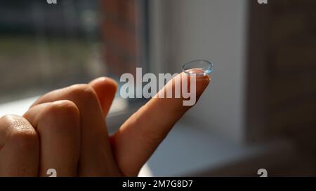 Nahaufnahme einer Kontaktlinse am Zeigefinger einer Frau. Stockfoto