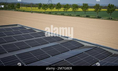 Auf dem Dach eines Industrieunternehmens werden Solarpaneele installiert Stockfoto