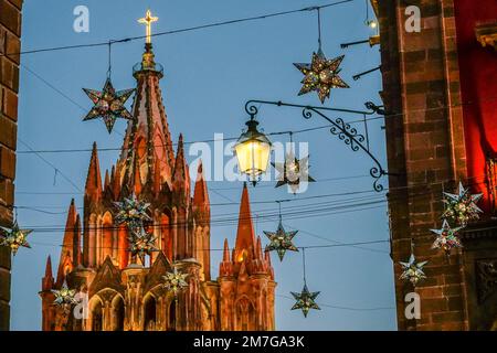 Farbenfrohe Sterndekorationen in Zinn zieren die berühmte Kirche Parroquia de San Miguel Arcangel, um das neue Jahr im historischen Viertel zu feiern, am 4. Januar 2023 in San Miguel de Allende, GTO, Mexiko. Stockfoto