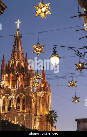 Farbenfrohe Sterndekorationen in Zinn zieren die berühmte Kirche Parroquia de San Miguel Arcangel, die das neue Jahr feiert, im zentralen historischen Viertel am 4. Januar 2023 in San Miguel de Allende, GTO, Mexiko. Stockfoto