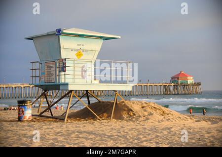 Ein Rettungsschwimmturm an einem kalifornischen Strand bei Sonnenuntergang. Weit dahinter liegt Huntington Beach Pi Stockfoto