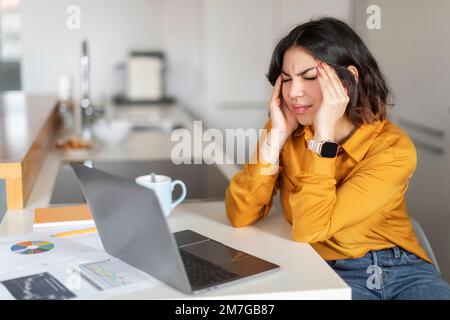 Porträt Einer Gestressten Jungen Arabischen Frau, Die Bei Der Arbeit Mit Einem Laptop Kopfschmerzen Hat Stockfoto