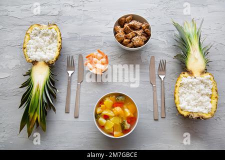 Reis mit Hühnern, Garnelen und Gemüse in süßer und saurer Sauce auf grauem Hintergrund, Draufsicht. Stockfoto