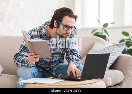 Konzentrierter, seriöser junger, kluger, weißer Student mit Brille schaut auf Laptop, Suchfehler Stockfoto