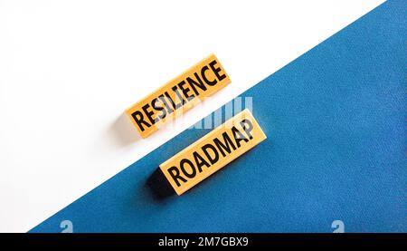 Roadmap-Symbol für Resilienz. Konzeptbegriff „Resilience“-Roadmap auf Holzblöcken getippt. Schöner weißer und blauer Papierhintergrund. Business und Resilienz Stockfoto