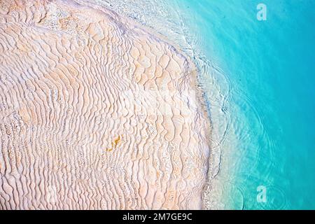 Blick auf die natürlichen Terrassen in Pamukkale an einem Sommertag. Nahaufnahme von Kalkstein und Wasser, das darüber fließt. Stockfoto