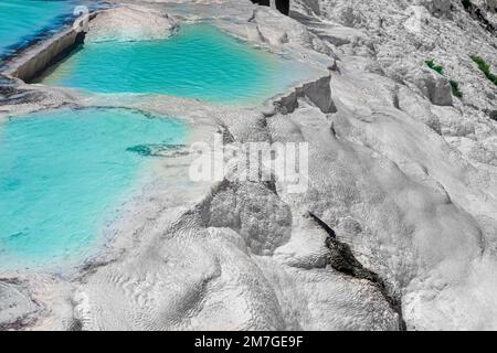 Blick auf die natürlichen Terrassen in Pamukkale an einem Sommertag. Nahaufnahme von Kalkstein und Wasser, das darüber fließt. Stockfoto