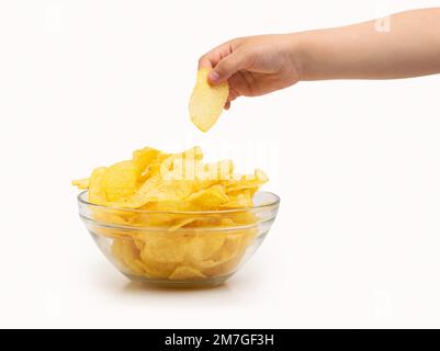 Nahaufnahme der Hand eines Kindes, die einen Kartoffelchip fängt oder mit weißem Hintergrund gebraten wird Stockfoto