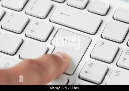 Nahaufnahme eines Fingers durch Drücken der Eingabetaste Stockfoto