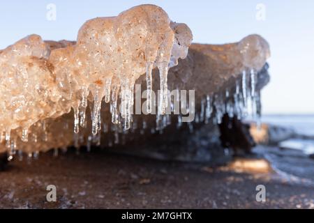 Schmelzende Eisscholle mit Eiszapfen liegt an der Ostseeküste, natürlicher Winterhintergrund Stockfoto