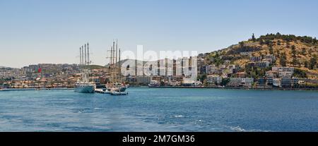 Kusadasi, Türkei - 2022. Mai: Malerischer Blick auf das Ufer und den Hafen der Stadt mit zwei großen Segelkreuzschiffen, die am Anlegesteg vor Anker liegen Stockfoto